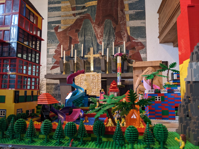 Auf dem Bild ist ein Ausschnitt der aufgebauten Stadt zu sehen, im Hintergrund sieht man einen Altar mit Kerzen.
